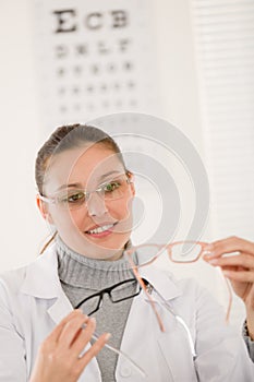 Optician doctor woman with glasses and eye chart