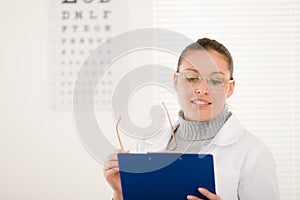 Optician doctor woman with glasses and eye chart