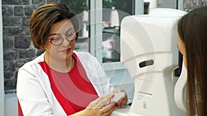 Optician doctor working with the refractometer machine.