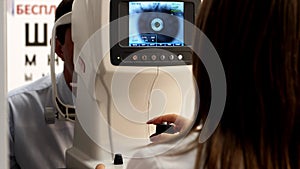 Optician doctor working with the refractometer machine.