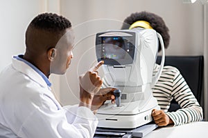 Optician Doing Optometry Eye Exam of black african american teen girl in modern clinic. Doctor and patient in ophthalmology clinic