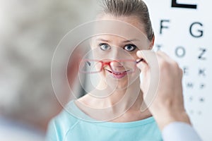 Optician giving glasses to the patient