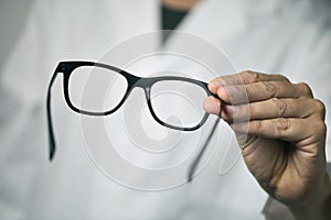 Optician man bringing a pair of eyeglasses