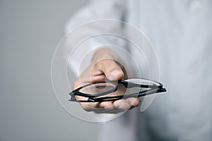 Optician man bringing a pair of eyeglasses