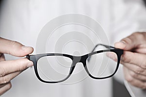 Optician man bringing a pair of eyeglasses