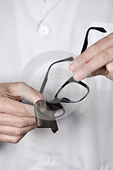 Optician man cleaning a pair of eyeglasses