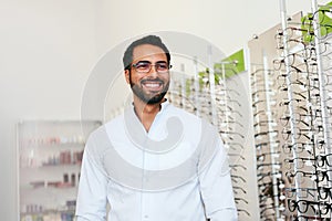 Optician Man Near Showcase With Eyeglasses At Glasses Shop