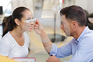 optician measuring bridge clients nose for glasses fitment photo