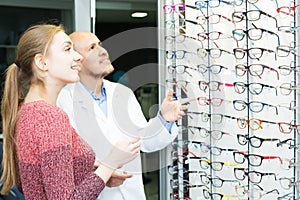 Optician offering glasses to woman