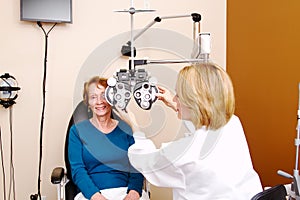 Optician preparing senior for eye exam