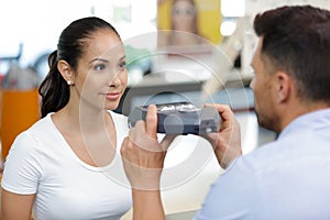 optician preparing to use handheld device to test clients vision