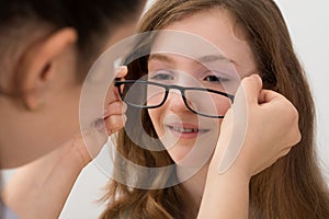Optician Putting Eyeglasses On A Patient