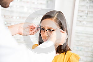 Optician putting glasses to at optics store