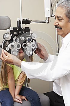 Optician In Surgery Giving Girl Eye Test