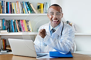 Optimistic african american male doctor at computer