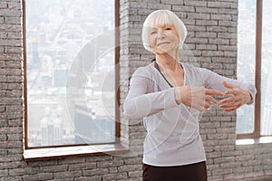 Optimistic aging woman tangoing at the dance lesson