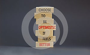 Optimistic is better symbol. Wooden blocks with words Choose to be optimistic it feels better. Beautiful grey background copy