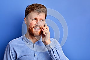 Optimistic caucasian male talk on phone with someone