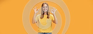 Optimistic charming woman with fair hair and no make-up in yellow t-shirt showing okay or approval gesture assuring
