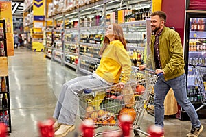 optimistic couple shopping together in grocery supermarket
