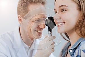 Optimistic dermatologist using dermatoscope at work