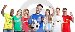 Optimistic french soccer fan with ball and fans from other count