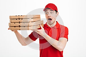 Optimistic guy dealer in red t-shirt and cap working in delivery