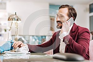 Optimistic mature man picking up phone