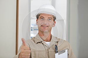 optimistic worker builder man shows thumb up