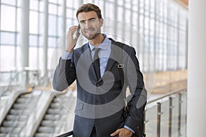 Optimistic Young Man on Phone Modern Bright Office Building