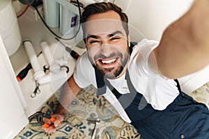 Optimistic young man plumber work in uniform