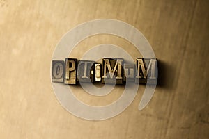 OPTIMUM - close-up of grungy vintage typeset word on metal backdrop