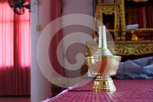 An optional focus golden water cup is housed in a Thai temple for Buddhist rituals.