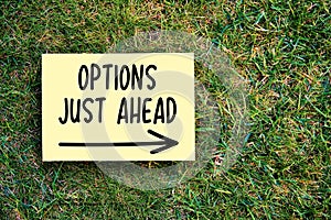 Options just ahead motivational message on paper on grass background. Inspirational quote to create future in business or life