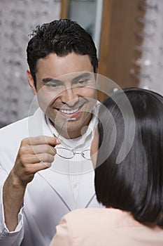 Optometrist Assisting Female Patient In Choosing Glasses