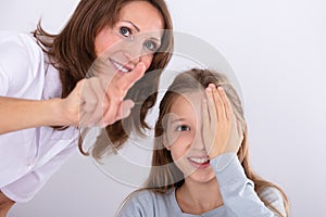 Optometrist Assisting Girl While Checking Eyesight