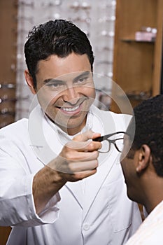 Optometrist Assisting Male Patient In Choosing Glasses