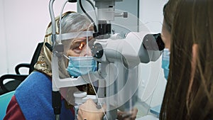 Optometrist checking eyesight to elderly woman. Female pensioner doing eye test