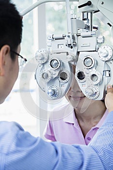 Optometrist doing an eye exam on young woman