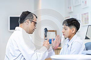 Optometrist doing sight testing for child patient in clinic, Indian child choosing eyeglasses in optics store, Boy doing eye test