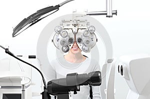 Optometrist exam, eyesight woman patient with phoropter in opti