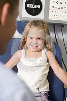 Optometrist in exam room with young girl