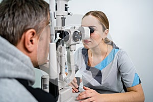 Optometrist examining the eyes of a male patient in a modern ophthalmology clinic. Eye doctor with man patient during an