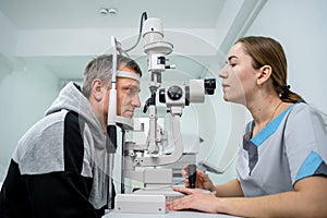 Optometrist examining the eyes of a male patient in a modern ophthalmology clinic. Eye doctor with man patient during an