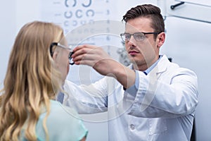 Optometrist examining female patient with phoropter