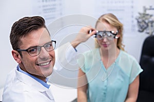 Optometrist examining female patient with phoropter