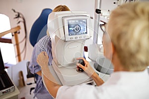 Optometrist examining patient in modern ophthalmology clinic