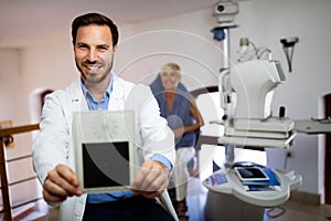 Optometrist examining senior woman in modern ophthalmology clinic