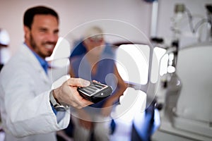 Optometrist examining senior woman in modern ophthalmology clinic