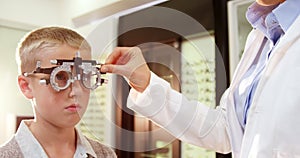 Optometrist examining young patient with chiropter